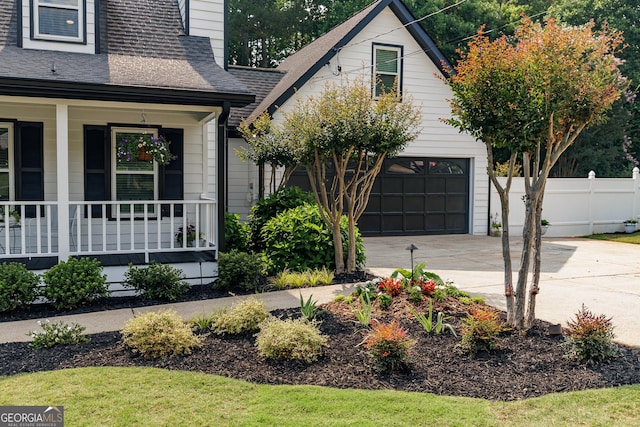 870 Rutherford Dr, Dacula, GA 30019 - view of front of home with covered porch, a garage, roof with shingles, driveway, and a chimney