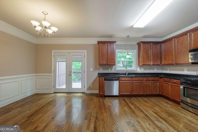 2264 Ewell Park Dr, Lawrenceville, GA 30043 - kitchen with stainless steel appliances, dark countertops, french doors, brown cabinetry, and a chandelier