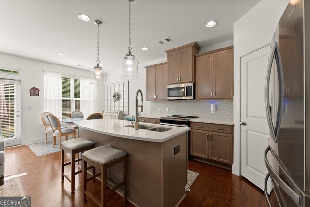61 N Auburn Landing Pl, Auburn, GA 30011 - kitchen featuring appliances with stainless steel finishes, a sink, dark wood-type flooring, a breakfast bar, and recessed lighting