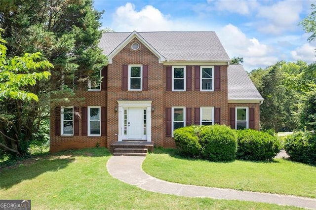 2196 Kildare Way, Kennesaw, GA 30152 - colonial home featuring a front lawn, brick siding, and roof with shingles