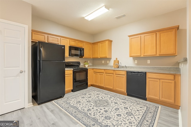 7432 Battlecreek Ln, Jonesboro, GA 30236 - kitchen with black appliances, light brown cabinetry, light countertops, and light wood-style floors