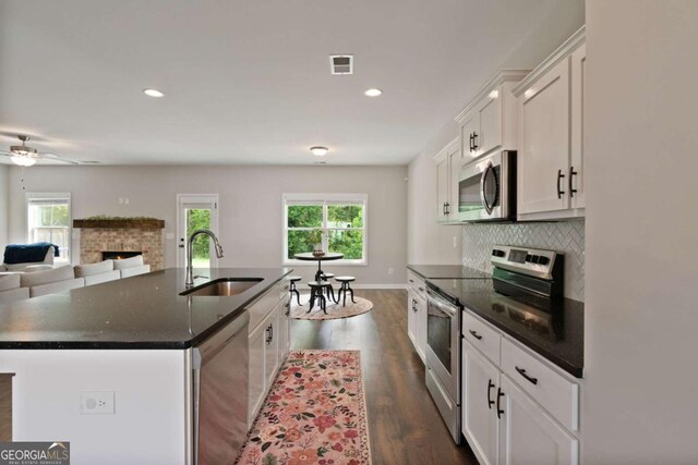 125 Kingston Cir, Carrollton, GA 30117 - kitchen with appliances with stainless steel finishes, a sink, healthy amount of natural light, white cabinets, and recessed lighting
