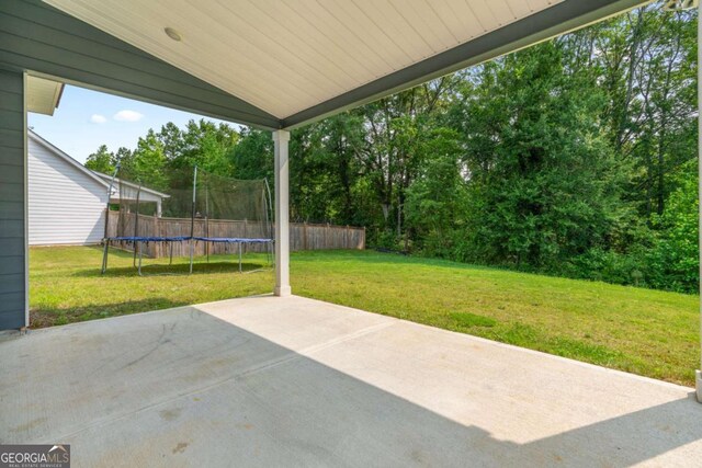 125 Kingston Cir, Carrollton, GA 30117 - view of patio with a trampoline and view of wooded area