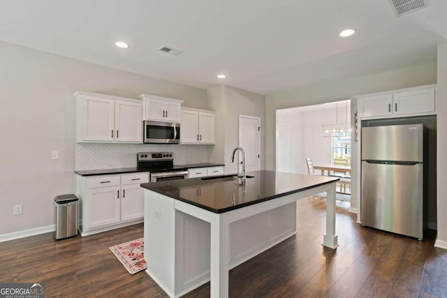 125 Kingston Cir, Carrollton, GA 30117 - kitchen featuring appliances with stainless steel finishes, a sink, dark countertops, dark wood-style flooring, and recessed lighting