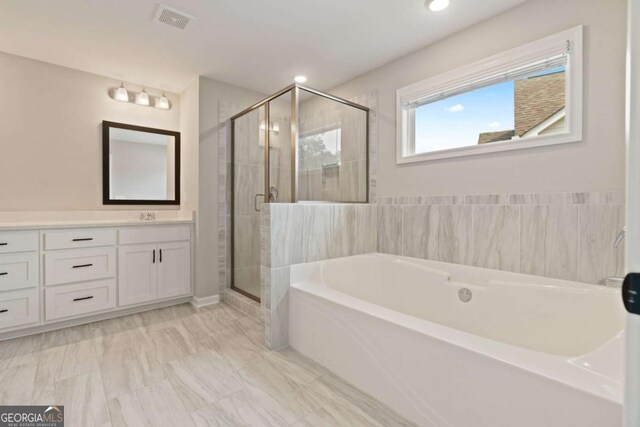 125 Kingston Cir, Carrollton, GA 30117 - full bathroom with vanity, a bath, a stall shower, recessed lighting, and marble look tiles