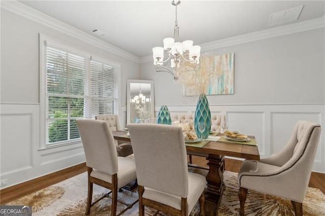 10 Nesbit Reserve Ct, Atlanta, GA 30350 - dining area with a chandelier, a decorative wall, crown molding, wood finished floors, and wainscoting