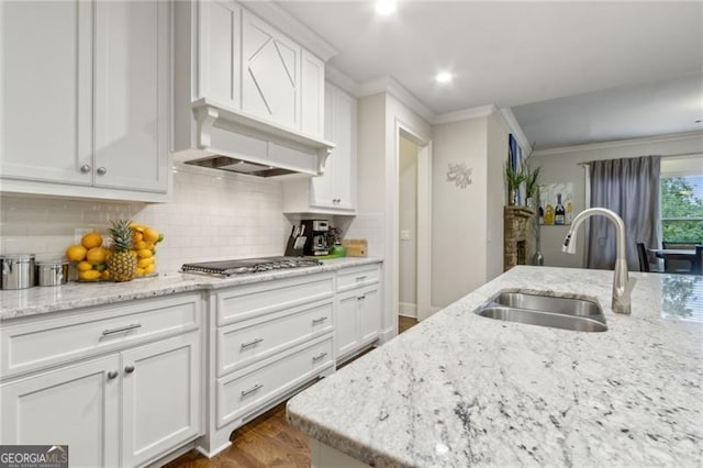 10 Nesbit Reserve Ct, Atlanta, GA 30350 - kitchen with stainless steel gas cooktop, crown molding, white cabinets, dark wood-style floors, and decorative backsplash
