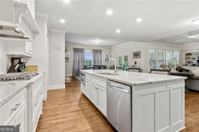 10 Nesbit Reserve Ct, Atlanta, GA 30350 - kitchen featuring appliances with stainless steel finishes, crown molding, a center island with sink, open floor plan, and white cabinets