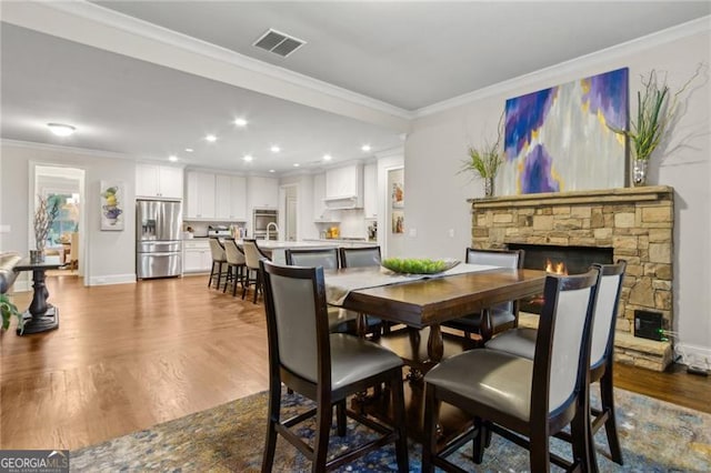 10 Nesbit Reserve Ct, Atlanta, GA 30350 - dining room featuring a fireplace, dark wood finished floors, ornamental molding, and recessed lighting
