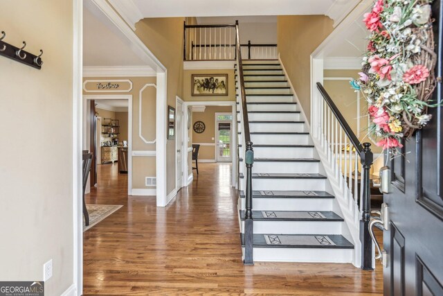 3480 Indian Shoals Rd, Dacula, GA 30019 - foyer featuring wood finished floors, crown molding, stairway, and baseboards
