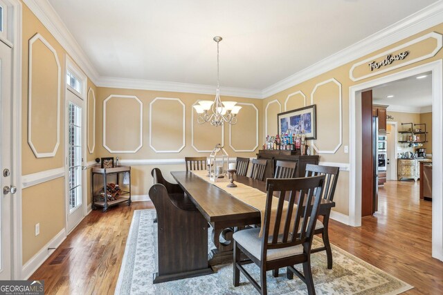 3480 Indian Shoals Rd, Dacula, GA 30019 - dining room with wood finished floors, crown molding, a chandelier, and baseboards