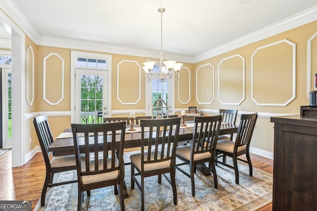 3480 Indian Shoals Rd, Dacula, GA 30019 - dining space featuring healthy amount of natural light, wood finished floors, ornamental molding, a chandelier, and baseboards