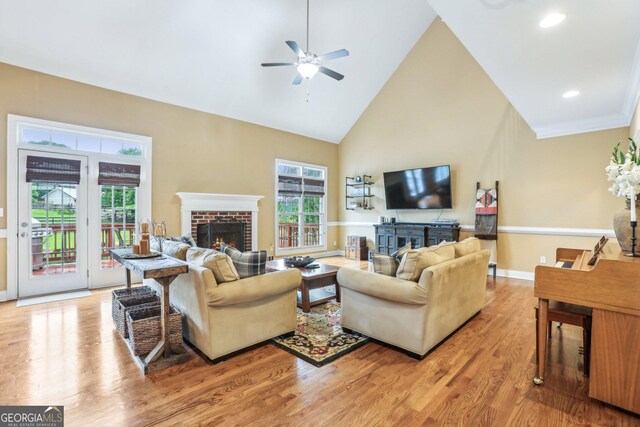 3480 Indian Shoals Rd, Dacula, GA 30019 - living area featuring a fireplace, a ceiling fan, light wood-style floors, high vaulted ceiling, and baseboards