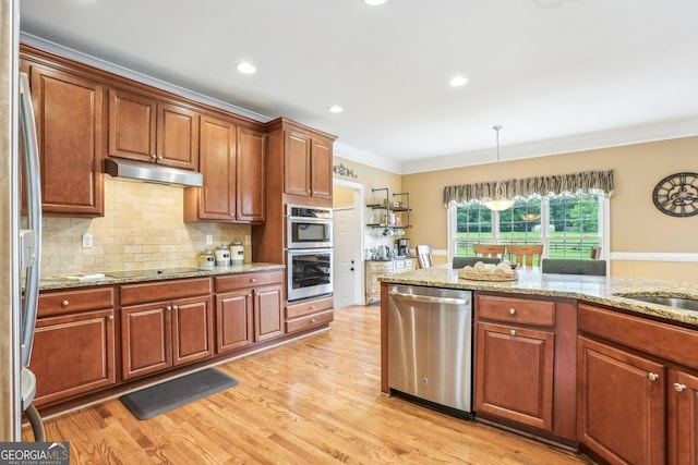 3480 Indian Shoals Rd, Dacula, GA 30019 - kitchen featuring stainless steel appliances, ornamental molding, light wood finished floors, under cabinet range hood, and decorative backsplash