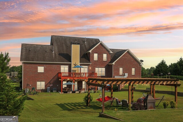 3480 Indian Shoals Rd, Dacula, GA 30019 - back of house at dusk featuring a deck, brick siding, a yard, a pergola, and a chimney