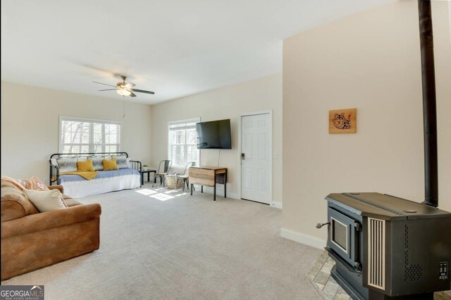 243 Degroff Ln, Rabun Gap, GA 30568 - living area featuring a wood stove, a ceiling fan, light colored carpet, and baseboards
