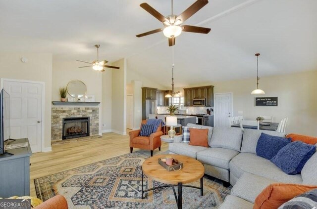 243 Degroff Ln, Rabun Gap, GA 30568 - living room featuring ceiling fan, light wood finished floors, a fireplace, high vaulted ceiling, and baseboards
