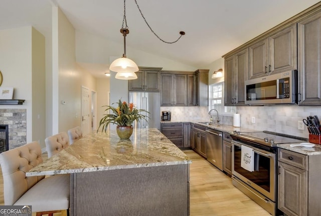 243 Degroff Ln, Rabun Gap, GA 30568 - kitchen featuring appliances with stainless steel finishes, lofted ceiling, a sink, light wood-type flooring, and decorative backsplash