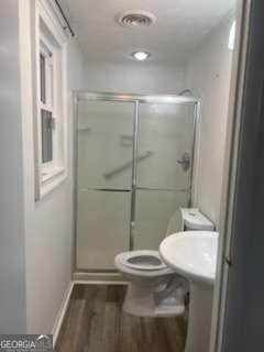 3785 Somerset Dr SW, Marietta, GA 30064 - bathroom featuring wood finished floors, a stall shower, and toilet