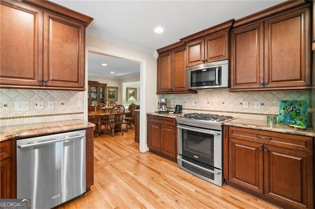226 Nacoochee Dr, Woodstock, GA 30188 - kitchen with stainless steel appliances, light wood-type flooring, tasteful backsplash, recessed lighting, and light stone countertops