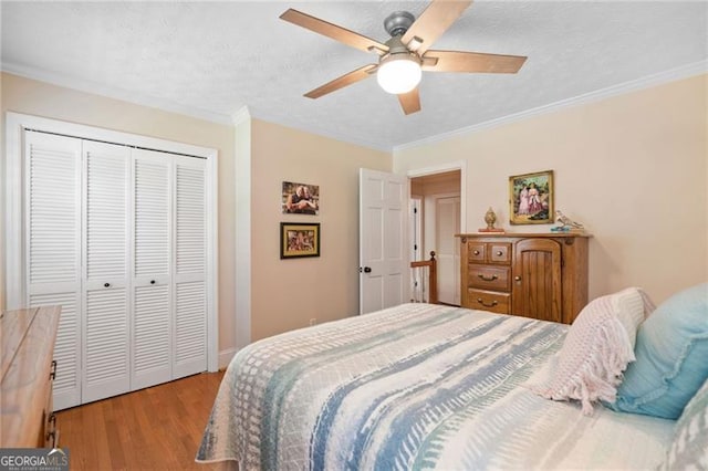 226 Nacoochee Dr, Woodstock, GA 30188 - bedroom with wood finished floors, crown molding, a closet, ceiling fan, and a textured ceiling