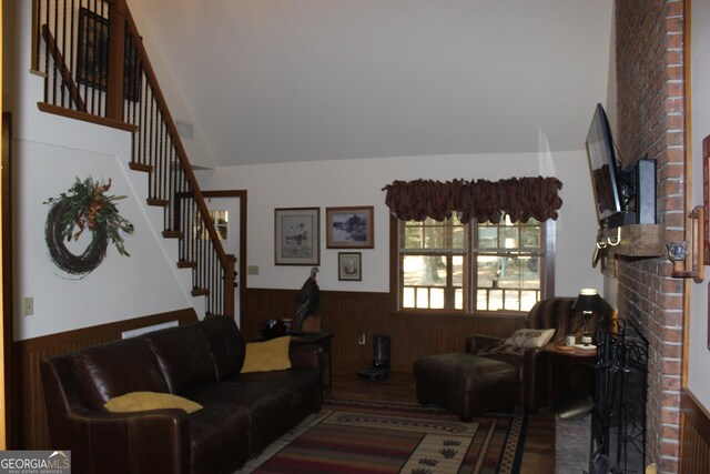 2879 Mcmillan Jernigan, Enigma, GA 31749 - living room with wainscoting, stairs, wooden walls, a brick fireplace, and wood finished floors