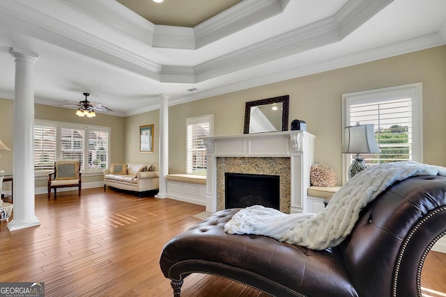 2450 Weber Heights Way, Buford, GA 30519 - living room featuring decorative columns, a tray ceiling, crown molding, wood finished floors, and a high end fireplace