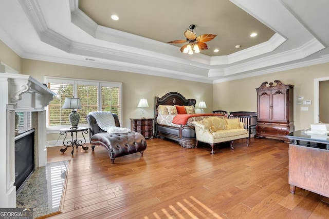 2450 Weber Heights Way, Buford, GA 30519 - bedroom featuring a raised ceiling, light wood-style floors, crown molding, a fireplace, and recessed lighting