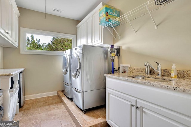2450 Weber Heights Way, Buford, GA 30519 - laundry area featuring independent washer and dryer, cabinet space, baseboards, and light stone finish floors