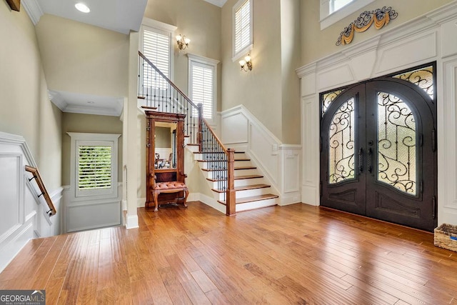 2450 Weber Heights Way, Buford, GA 30519 - foyer entrance featuring a high ceiling, stairs, french doors, light wood-style flooring, and wainscoting