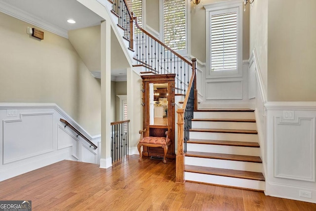 2450 Weber Heights Way, Buford, GA 30519 - staircase with a decorative wall, wood finished floors, ornamental molding, and a wainscoted wall