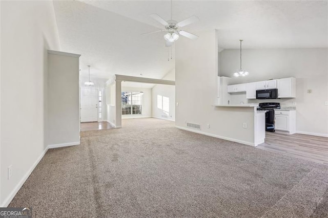 245 London Ln, Hiram, GA 30141 - unfurnished living room featuring light colored carpet, high vaulted ceiling, ceiling fan, and a chandelier
