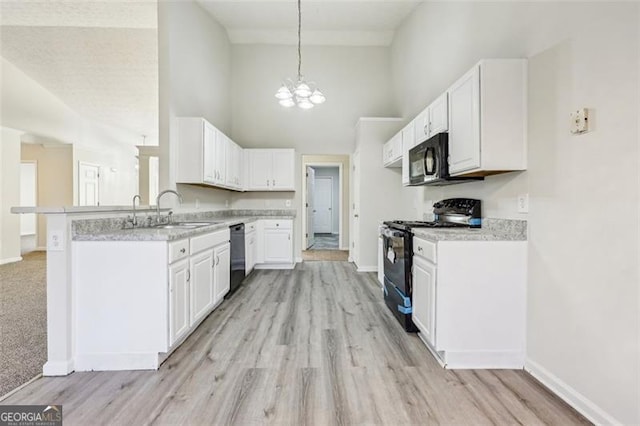 245 London Ln, Hiram, GA 30141 - kitchen featuring black appliances, high vaulted ceiling, a peninsula, light countertops, and white cabinetry
