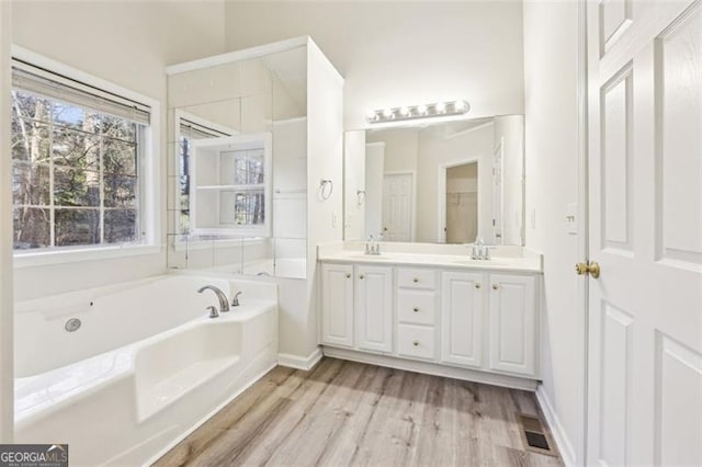 245 London Ln, Hiram, GA 30141 - full bathroom with double vanity, a bath, and wood finished floors