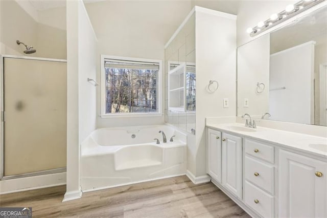 245 London Ln, Hiram, GA 30141 - bathroom featuring a bath, wood finished floors, double vanity, and a stall shower