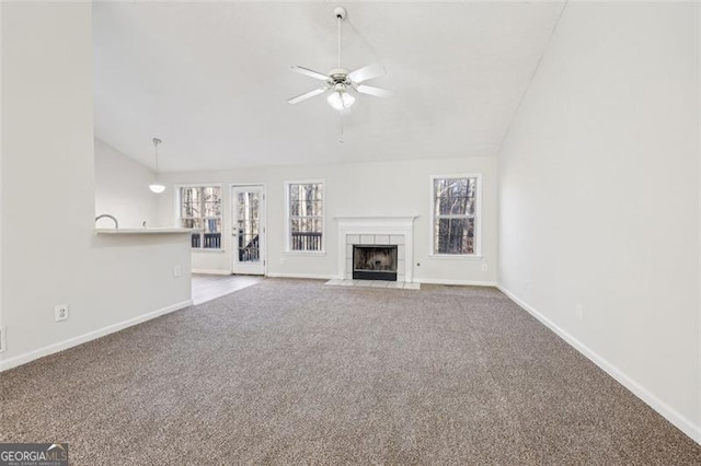 245 London Ln, Hiram, GA 30141 - unfurnished living room with carpet flooring, vaulted ceiling, ceiling fan, and a tile fireplace