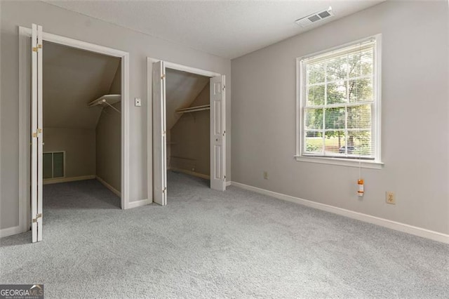 233 Oakridge Dr, Cartersville, GA 30121 - unfurnished bedroom with carpet, a walk in closet, lofted ceiling, baseboards, and a closet