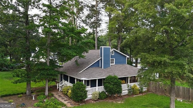 233 Oakridge Dr, Cartersville, GA 30121 - view of front of house with covered porch, a shingled roof, view of wooded area, and a chimney