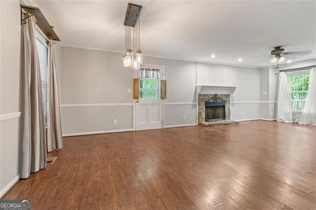 233 Oakridge Dr, Cartersville, GA 30121 - unfurnished living room with wood finished floors, ceiling fan, a stone fireplace, baseboards, and ornamental molding