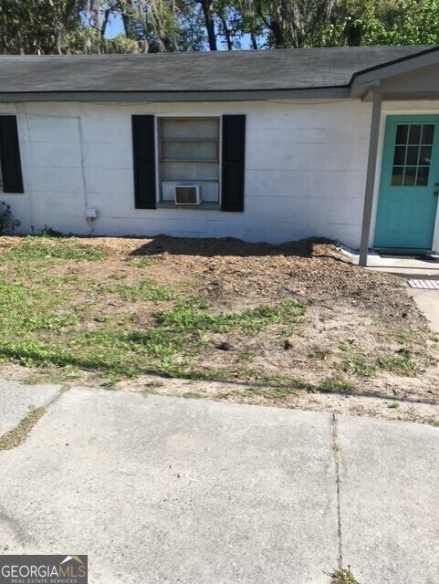 2214 Shell Rd, Savannah, GA 31404 - view of home's exterior featuring concrete block siding, roof with shingles, and cooling unit