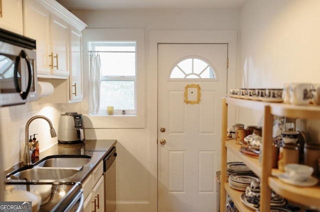 351 Cherokee Ave SE Apt 10, Atlanta, GA 30312 - kitchen featuring appliances with stainless steel finishes, decorative backsplash, white cabinets, a sink, and dark stone countertops