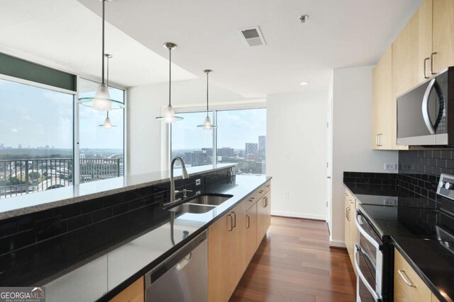 361 17th St NW Unit 1702, Atlanta, GA 30363 - kitchen with stainless steel appliances, a sink, modern cabinets, dark wood finished floors, and light brown cabinetry