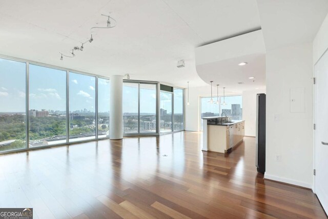 361 17th St NW Unit 1702, Atlanta, GA 30363 - unfurnished living room with floor to ceiling windows, wood finished floors, a sink, plenty of natural light, and track lighting