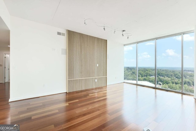 361 17th St NW Unit 1702, Atlanta, GA 30363 - unfurnished room featuring expansive windows, wood finished floors, and rail lighting