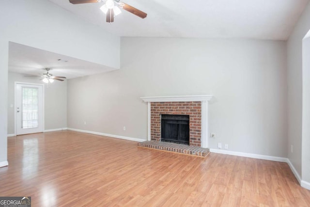 1214 Tyne Way, Stone Mountain, GA 30088 - unfurnished living room featuring a ceiling fan, light wood-style floors, a fireplace, baseboards, and vaulted ceiling