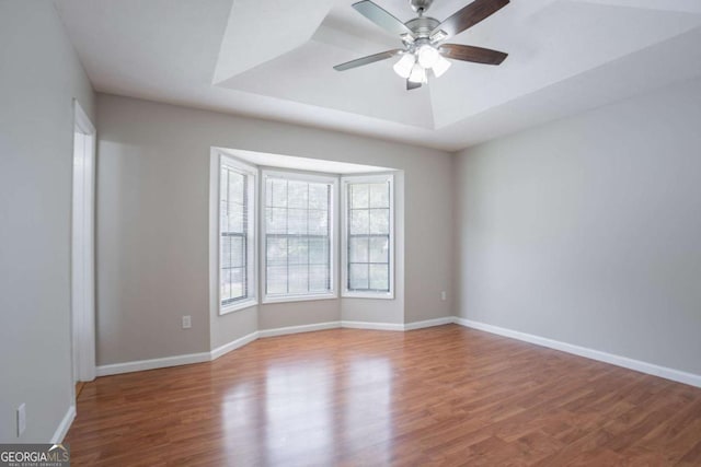 1214 Tyne Way, Stone Mountain, GA 30088 - empty room with wood finished floors, ceiling fan, a tray ceiling, and baseboards