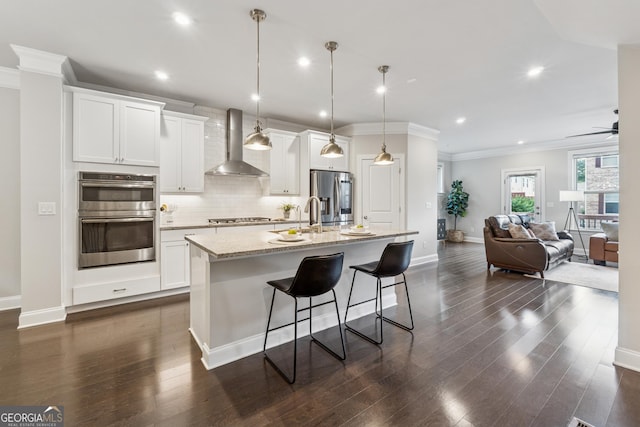 4012 Townsend Ln, Dunwoody, GA 30346 - kitchen with appliances with stainless steel finishes, wall chimney exhaust hood, a center island with sink, a breakfast bar, and tasteful backsplash