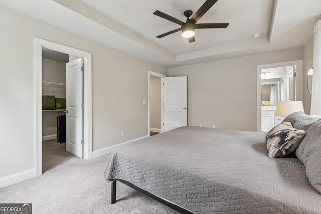 4012 Townsend Ln, Dunwoody, GA 30346 - carpeted bedroom with a tray ceiling, a walk in closet, connected bathroom, and ceiling fan