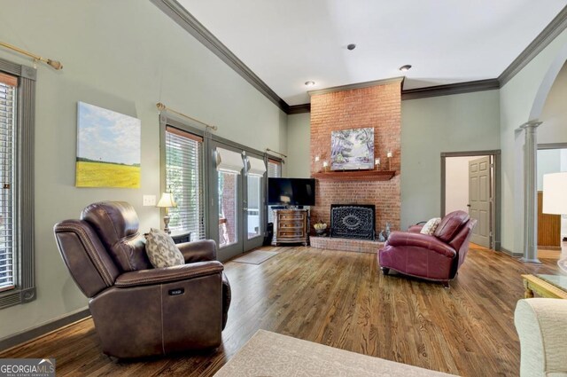 312 Sterling Rd, Jasper, GA 30143 - living room with ornate columns, ornamental molding, wood finished floors, a fireplace, and a high ceiling