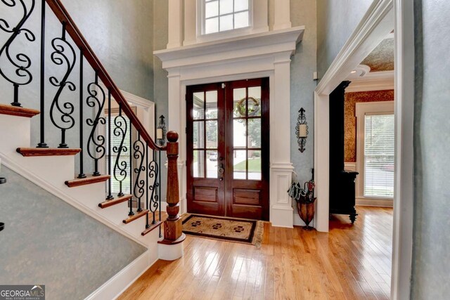 3085 Saint Andrews Dr, Duluth, GA 30096 - foyer featuring french doors, wood-type flooring, a towering ceiling, stairs, and crown molding